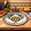 Round talavera bathroom sink bird floral design Mexico styled in a Mediterranean kitchen with colorful tile backsplash