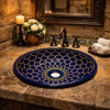 Round talavera bathroom sink blue mandala design Mexico placed in a hacienda bathroom with rustic stone and warm textures