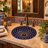 Round talavera bathroom sink blue mandala design Mexico placed in a hacienda bathroom with rustic stone and warm textures