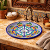Round talavera bathroom sink blue floral design Mexico placed in a hacienda bathroom with stone walls and warm textures