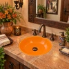 Round Mexican bathroom sink solid orange talavera design featured in a hacienda powder room