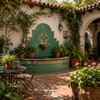 Handmade washed green Mexican talavera tiles for serene interiors enhancing a Spanish courtyard with fountain and garden accents