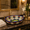 Double sided hHand painted oval floral talavera bathroom sink in luxury bathroom with elegant lighting