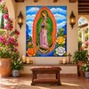 Our lady of Guadalupe tile mural in a covered patio sanctuary with arches and pottery.