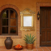Colonial Mexican tin mirror with sunburst design displayed in the entry of a Spanish Revival style house