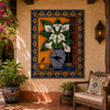 Talavera tile mural with calla lilies in a hacienda patio with terracotta floors and greenery.