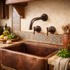 Custom wall-mounted bronze faucet with curved spout and artisan finish in a Spanish revival kitchen