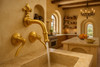 Brass kitchen faucet Fleur-de-Lis installed in Tuscan farmhouse kitchen with stone counters.