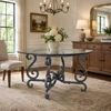 Wrought iron table base with ornate scrolls with glass top in an elegant dining room