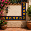 Sunflower mexican relief tile panel mounted on an outdoor garden wall with terracotta flooring