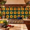 Sunflower mexican relief tile installed as a kitchen backsplash with warm lighting