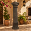 Rustic cantera stone column with carved capital in a Mediterranean courtyard with rustic stone
