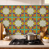 Mexican Talavera relief floral medallion tile in green blue and yellow installed as kitchen backsplash with strong color contrast