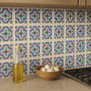Mexican relief tile blue cross with white 4x4 border pattern installed on a rustic kitchen backsplash with natural light