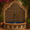 Mexican relief tile black orange star framing an outdoor fountain wall in terracotta courtyard