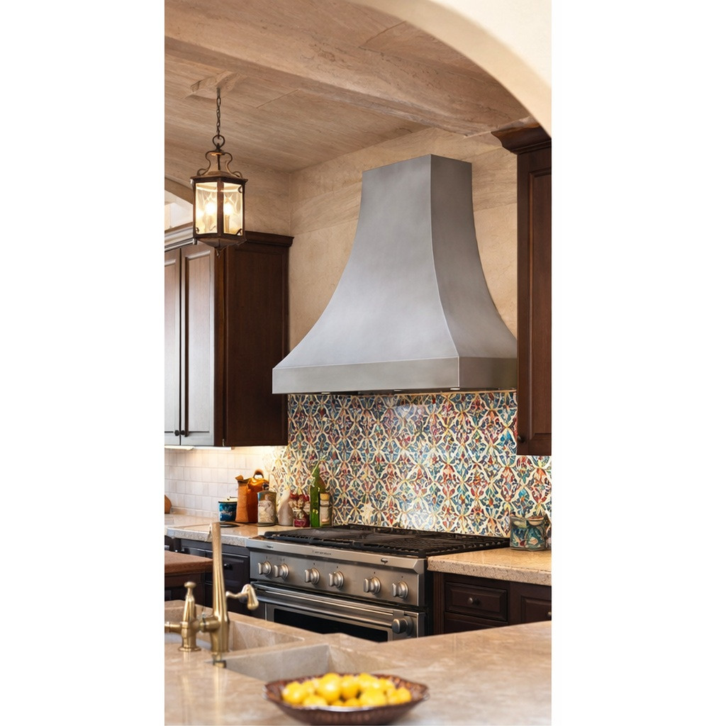 Smooth zinc range hood with natural finish installed in a Spanish Revival style kitchen