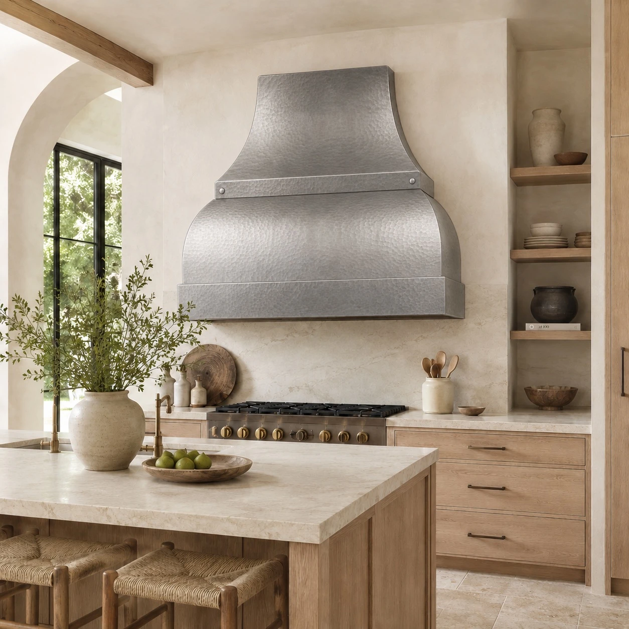 Organic modern kitchen with hammered zinc bell range hood, boxed apron, wood, stone, and plaster