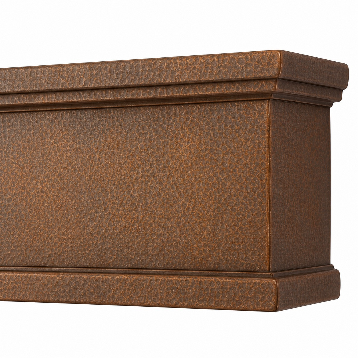 Close-up of hammered copper range hood apron with layered molding and finished side return