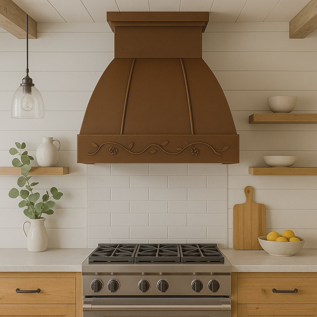 Copper range hood with a floral motif in a farmhouse kitchen, paired with warm wood cabinetry and light tile backsplash
