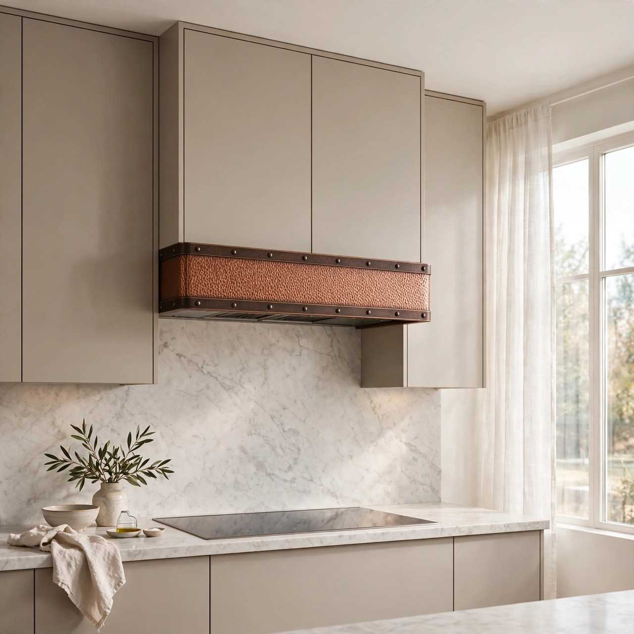 Warm transitional kitchen with hammered copper under-cabinet hood and dark patina border bands