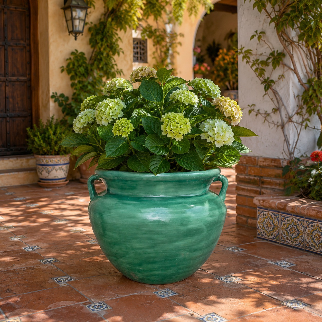 Green ceramic Talavera planter with handles decorating a sunlit Spanish patio garden