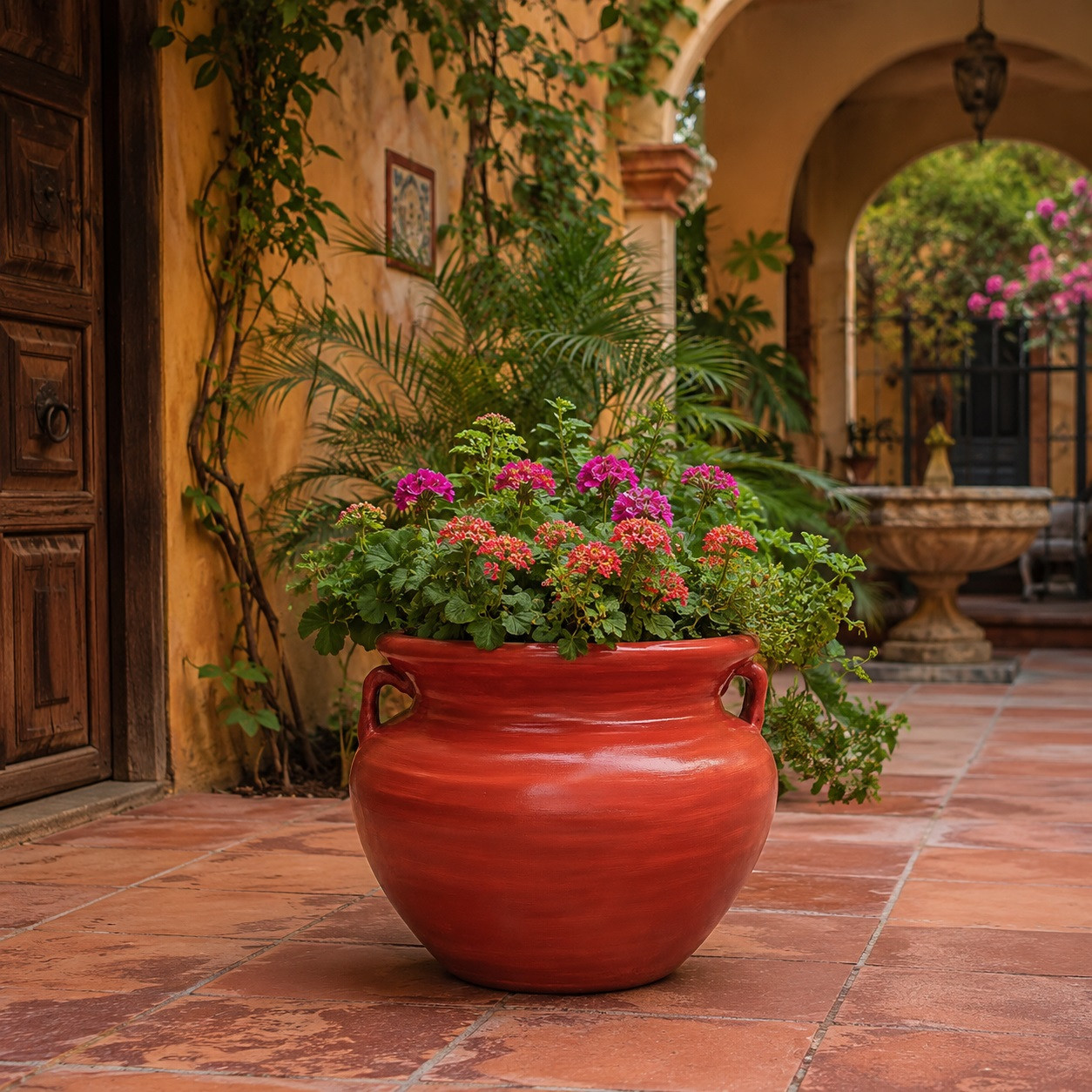 Red Talavera planter with flowering plants displayed in a colorful Mexican courtyard