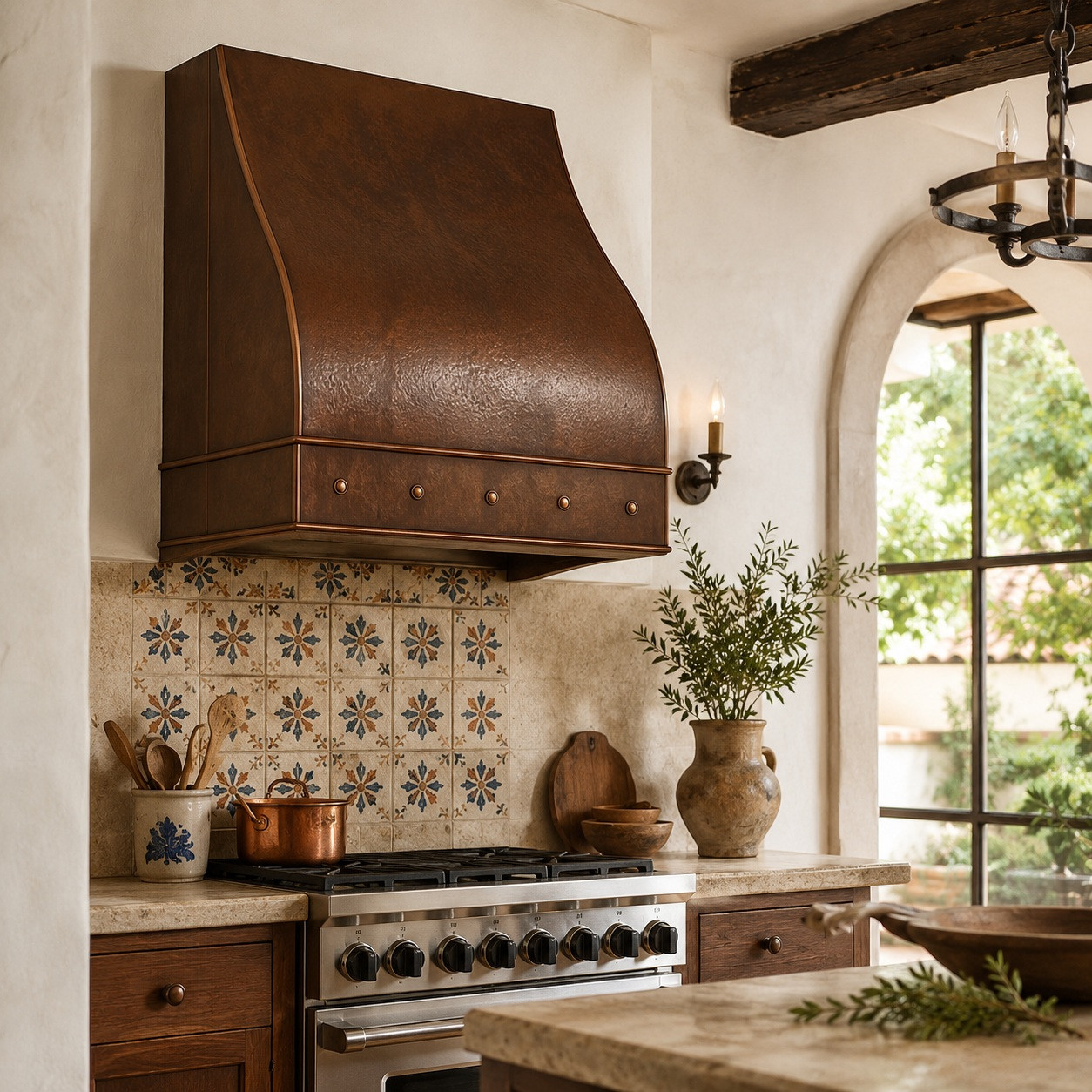 Under-cabinet hammered copper range hood with curved front in a Spanish kitchen