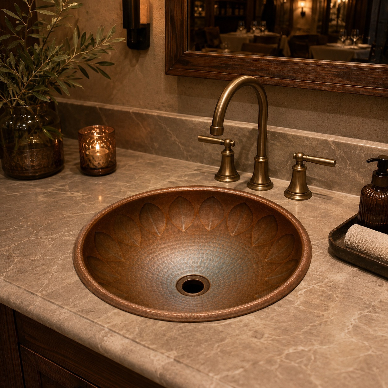 Leaf carved round copper sink showcased in a boutique restaurant washroom adding artisanal depth and organic copper texture