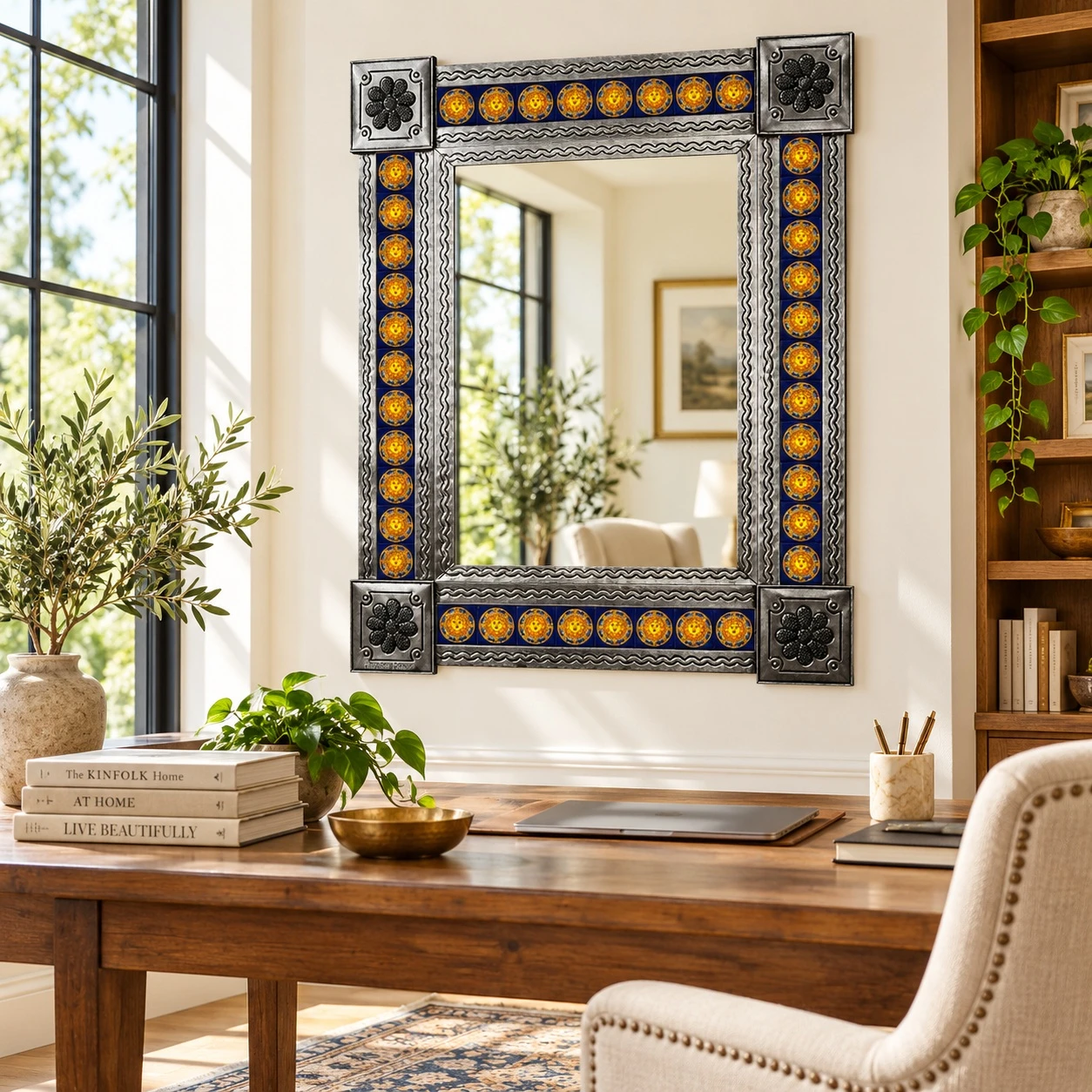 Cobalt blue and yellow Sun Talavera tile mirror in bright home office with wood desk, shelving, plaster walls, and natural light