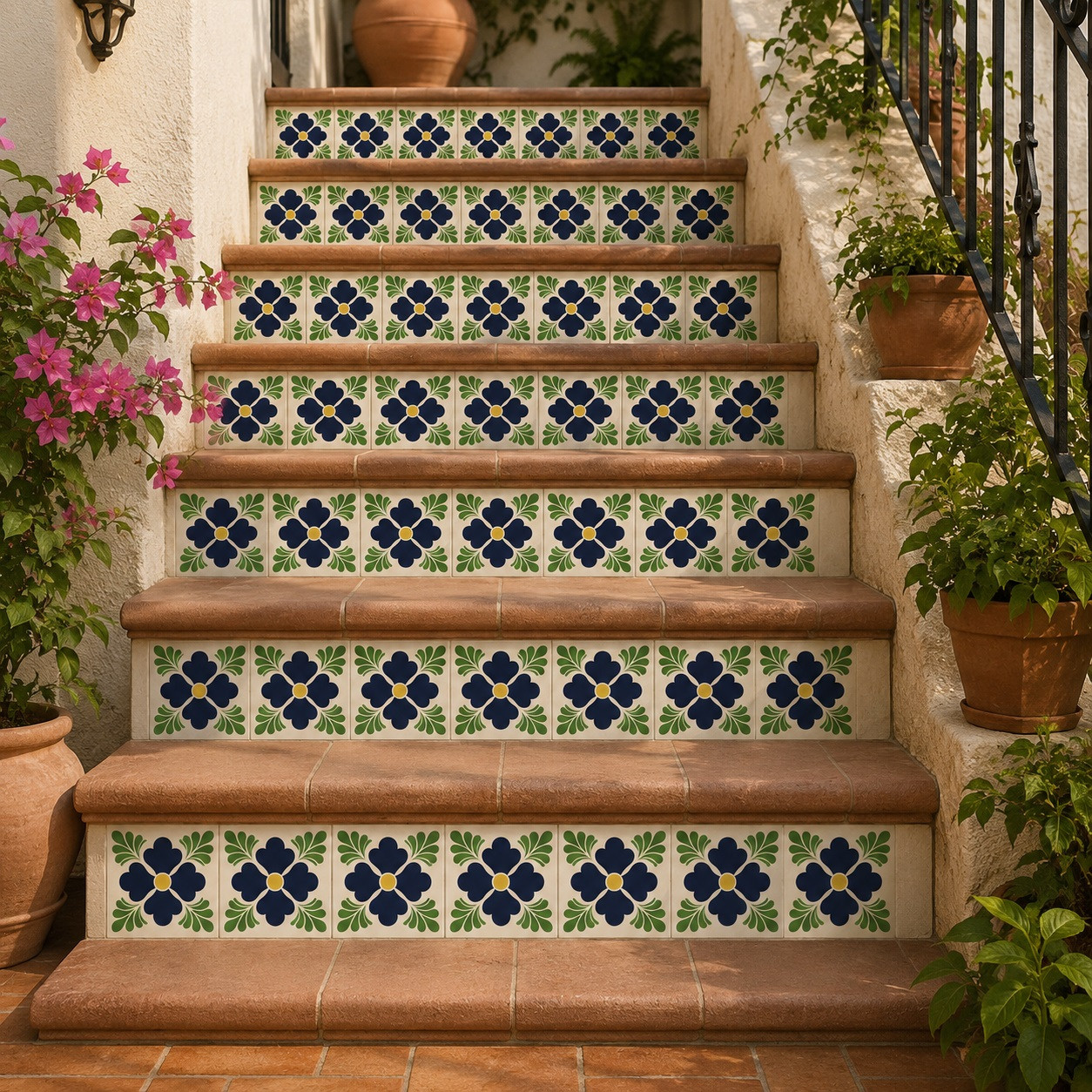 Mexican tile with dark floral fans decorating terracotta stair risers in a rustic outdoor setting