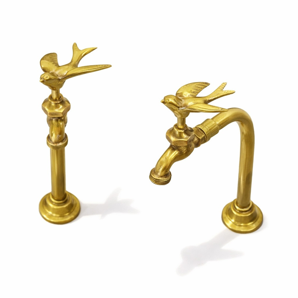 Warm golden brass bird handle bathroom faucets with sculptural handles, polished metal finish on slim tap bodies with stepped bases