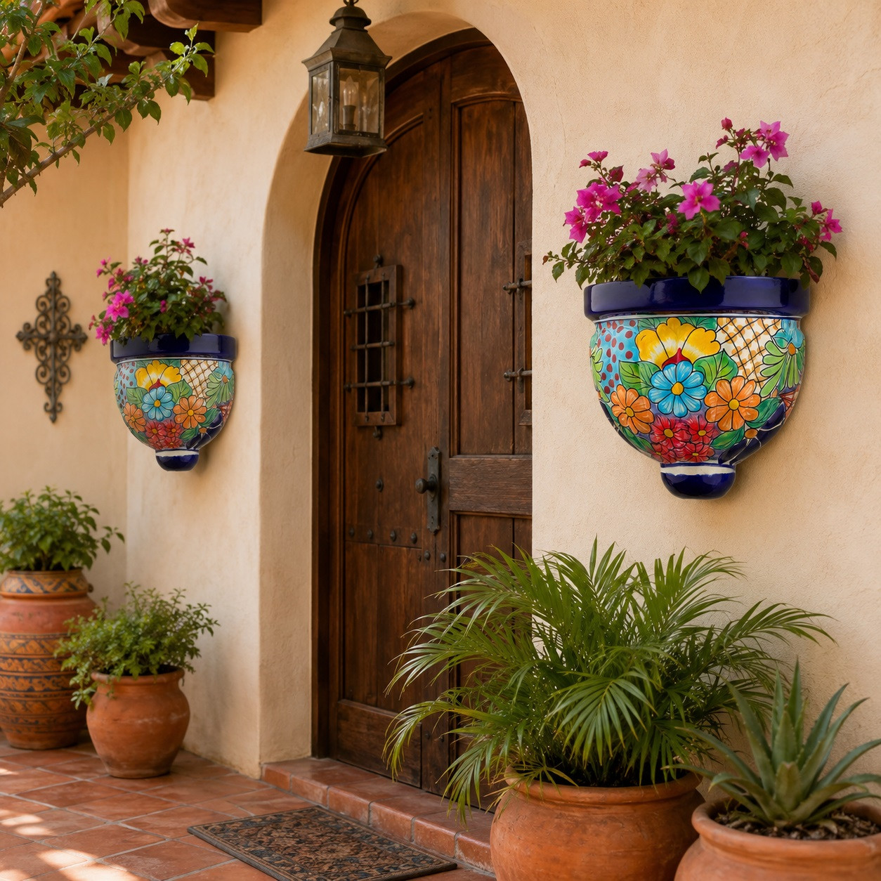 Pair of multicolor talavera wall sconces with plants beside a hacienda entryway