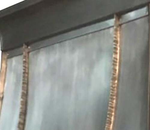 close up of the Houston style pewter range hood highlighting its gently sloping shape.