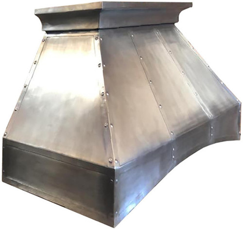 Side profile view of handcrafted pewter range hood with Mexican design on white background showing tapered silhouette and curved apron