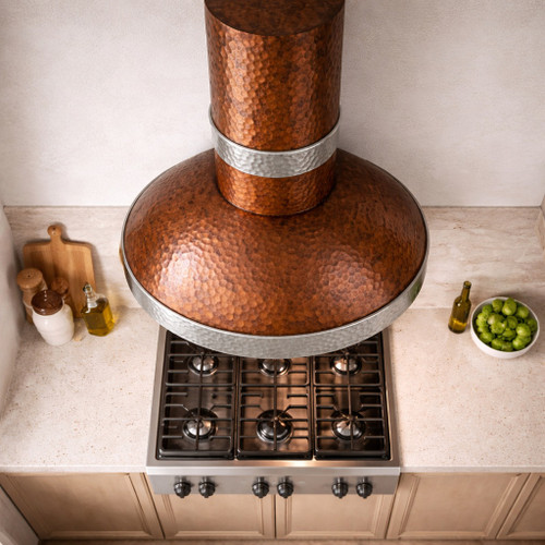 Hammered copper range hood with round chimney and zinc bands in kitchen island configuration
