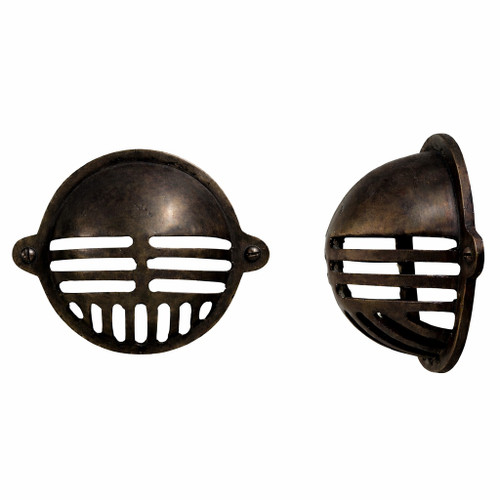 Compact industrial brass wall light shade with dark aged finish, domed profile with protective grille and deep patina on metal surface