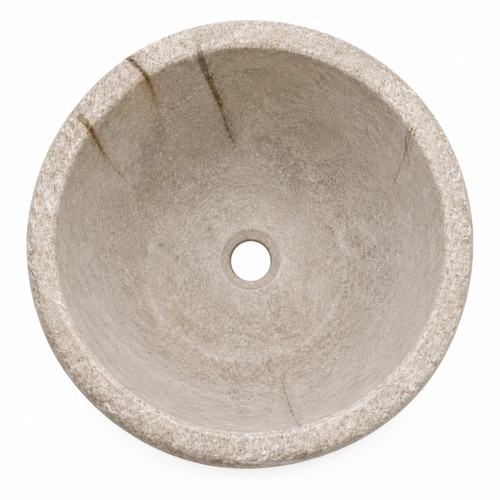 Top view of round cantera stone vessel sink with centered drain hole and handcrafted stone surface