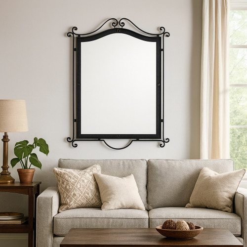 Hand-forged wrought iron mirror with an arched scroll crest decorating a wall of the traditional style living room