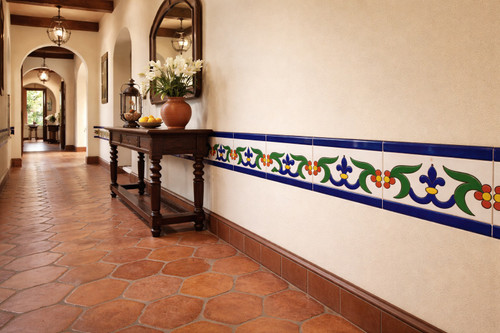Cobalt leaf talavera border tile with medallion framing a hallway wall in a colonial style interior