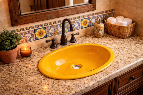 Solid yellow talavera bathroom sink featured in a restaurant washroom with warm lighting