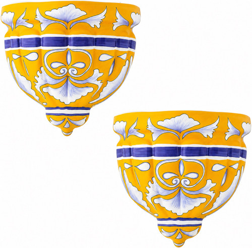 Two Mexican talavera wall sconces with blue and orange motifs on white