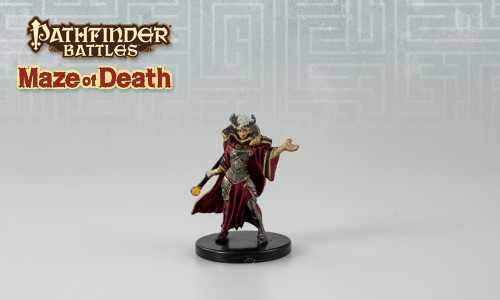 This diabolical mystic wears steely armor with red robes and gold accents, the robe's high collar framing the elaborate, horned headpiece settled around her face and into her gray hair. One hand is held out in a beckoning gesture while the other holds a glowing wand at her side. (Front View)