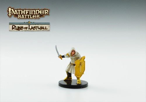 A soldier of Lastwall dressed in white, hooded robes with gold accents. One hand holds up a sword ready to strike while the other holds a golden shield bearing the mark of Iomedae. (Front View)