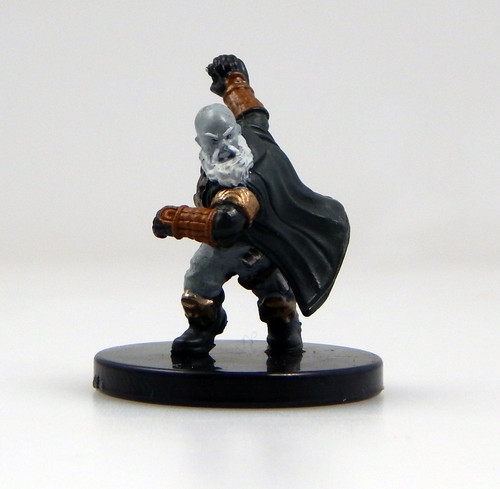 An image of a charging gray-skinned, bald duergar bombardier in dark, muted clothing and cloak, winding up to roll a bomb like a bowling ball. (Front View)