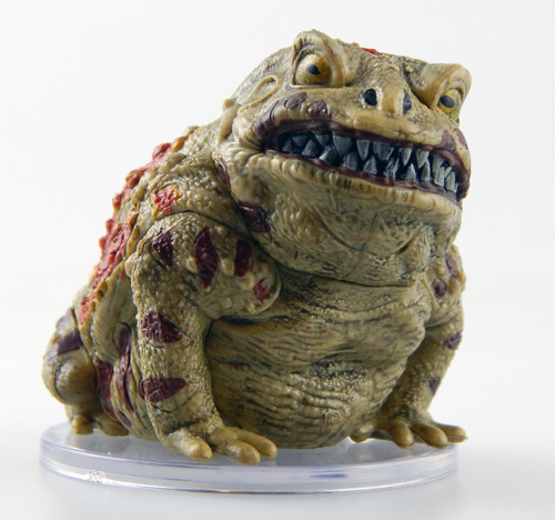 Stubby warts dot the skin of this horse-sized brown toad. Its throat bulges and ripples as though about to croak, though it looks fairly irate with massive teeth bared in a foul grimace. (Front View)