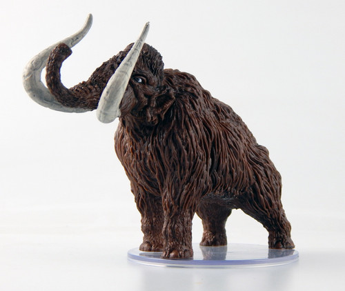 This huge elephantine creature is covered in a thick, shaggy coat of brown fur. It lets out a territorial trumpet from its long trunk, curling upward between two long, curved tusks. (Side View)