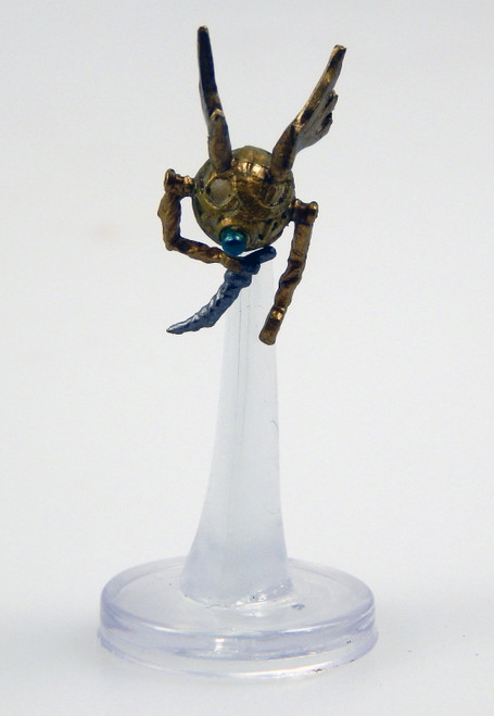 A sphere of bronze and copper set with a single eye, this winged creature has two clawed hands, one of which clutches a knife. (Front View)