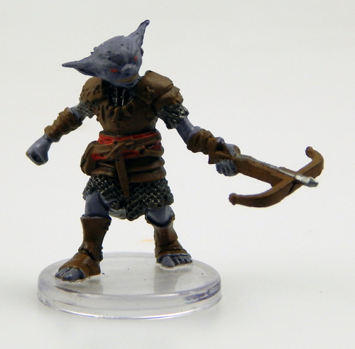 Standing as tall as a human, this muscular, gray-skinned creature peers about with tiny, observant eyes. It wears leather armor over a chain shirt. One hand holds out a loaded crossbow ready to fire. (Front View)