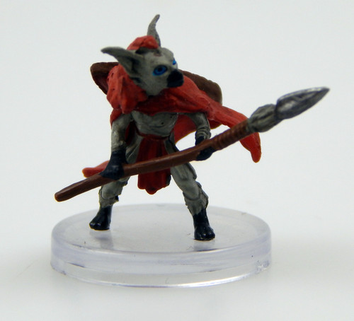 Ant gnolls are a smaller heritage of kholo, often distinguished by their proportionally larger ears. They are often scavengers dispatched to battlefields to gather the bones of their fallen allies. Rather than fight, many will choose to run from a confrontation. This ant gnoll wears a bright read cape and carries a shield on its back, both hands holding a spear ready to defend. (Front View)