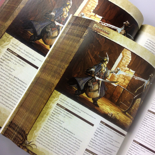 Pathfinder Roleplaying Game Core Rulebook (OGL) Pocket Edition image of pages from the inside of the hardcover and softcover books, highlighting an image of a cleric of the sun god blasting an undead foe with a beam of light.